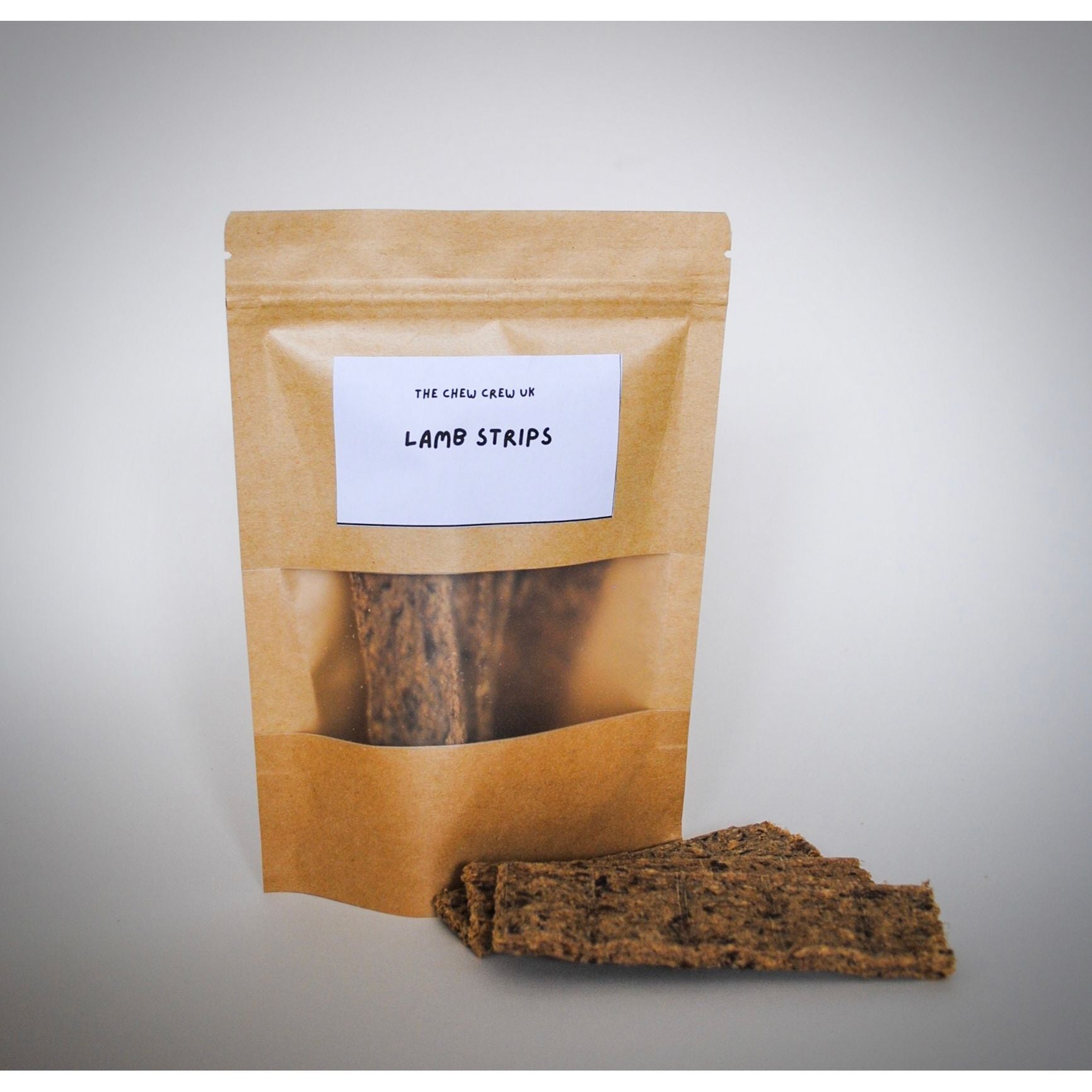 Kraft paper packaging with 'Lamb Strips' on a gray background. Containing lamb strips