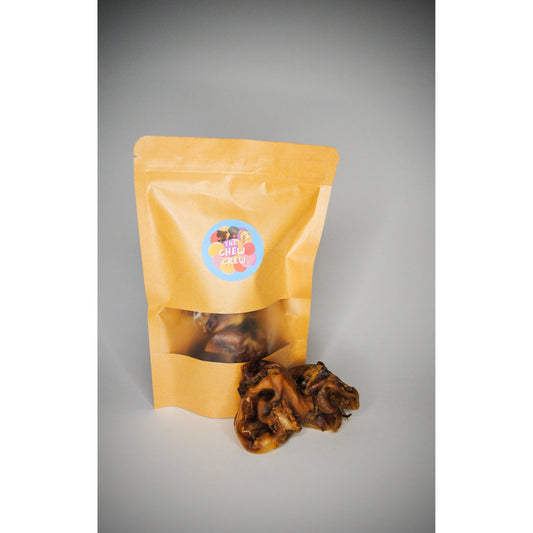 Yellow packaging bag with a label containing dried inner pigs ear on a grey background